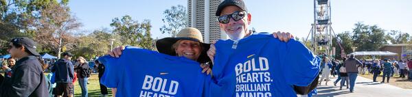 UCR alumnus holding a UCR bold heart. brilliant minds. t-shirt